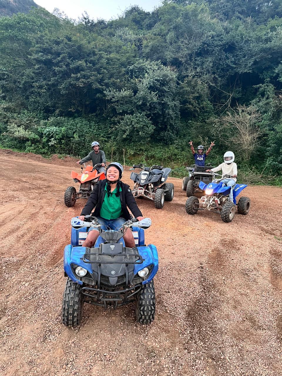 Quad bikers riding on a dirt track through a forest